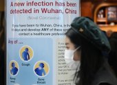 A woman wearing a face mask passes a Public Health England sign, warning passengers arriving on flights into the UK, that a virus, Coronavirus, has been detected in Wuhan in China, at Terminal 4 of London Heathrow Airport in west London on January 28, 2020. - Chinese President Xi Jinping said Tuesday the country was waging a serious fight against the "demon" coronavirus outbreak and pledged transparency in the government"s efforts to contain the disease. (Photo by DANIEL LEAL-OLIVAS / AFP)