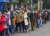 NANNING. Habitantes de esta ciudad china, hace fila al pie de una farmacia, en busca de mascarillas que ha vuelto un producto escaso y caro.