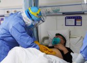 This photo taken on January 28, 2020 shows a medical staff member checking a patient infected by the novel coronavirus inside an isolation ward at a hospital in Zouping in China"s easter Shandong province. - China faced deepening isolation over its coronavirus epidemic on February 1 as the death toll soared to 259, with the United States leading a growing list of nations to impose extraordinary Chinese travel bans. (Photo by STR / AFP) / China OUT