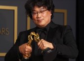 Bong Joon Ho juega con sus dos estatuillas por Mejor director y guion.
