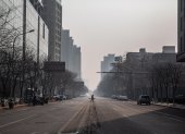 PEKÍN. Una persona transita por una avenida totalmente desolada. El temor y las restricciones aumentan en China, a causa del coronavirus.