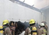 Bomberos ingresan al edificio para calmar las llamas.