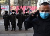 Security guards wearing protective face masks, amid concerns of the COVID-19 coronavirus outbreak, patrol in a shopping area in Beijing on February 17, 2020.   The death toll from China"s COVID-19 coronavirus epidemic jumped to 1,770 after 105 more people died, the National Health Commission said on February 17. More than 70,500 have now been infected nationwide by the virus, which first emerged in December in central Hubei province before spreading across the country. / AFP / GREG BAKER

 CHINA-HEALTH-VIRUS