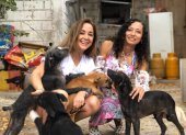 A la izquierda, Daysi Zambrano junto a la publicista Tatiana Elizalde, en compañía de varios canes adoptados.