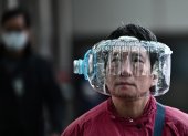 A woman wears a plastic water bottle with a cutout to cover her face, as she walks on a footbridge in Hong Kong on January 31, 2020, as a preventative measure following a virus outbreak which began in the Chinese city of Wuhan. - The World Health Organization, which initially downplayed the severity of a disease that has now killed 170 nationwide, warned all governments to be "on alert" as it weighed whether to declare a global health emergency. (Photo by Anthony WALLACE / AFP)