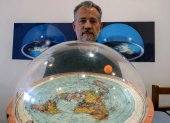 Brazilian self-avowed flat-Earth conspiracy theorist Anderson Neves holds a model of the flat earth surrounded by a dome during an interview with AFP in Sao Paulo, Brazil, on February 13, 2020. - Eleven million people in Brazil, 7% of its population, believe that the Earth is flat, according to Datafolha polling institute. (Photo by Florence GOISNARD / AFP)
