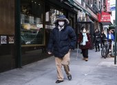 Personas usan mascarillas al caminar por el barrio chino de Nueva York.