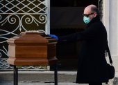 A man touches the coffin of his mother during a funeral service in the closed cemetery of Seriate, near Bergamo, Lombardy, on March 20, 2020 during the country"s lockdown aimed at stopping the spread of the COVID-19 (new coronavirus) pandemic. (Photo by Piero Cruciatti / AFP)