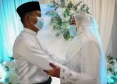 Malaysia. Mohammad Nor Azwan Ishak, de 27 años, y la novia, Nuramiraalia Noorbashah, de 25, usan mascarillas como medida preventiva contra el COVID-19.