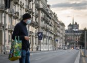 A man wearing a face mask uses a pedestrian crossing in front of Saint-Pierre Cathedral in Geneva on March 20, 2020, as the Swiss government further tightened measures against COVID-19, but said it would not follow other countries in ordering full confinement. (Photo by Fabrice COFFRINI / AFP)