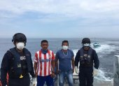 Dos de los pescadores rescatados con marinos de la Armada del Ecuador que los salvaron.