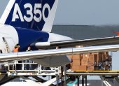Trabajadores descargan del avión Airbus A350-1.000 máscaras faciales procedentes de China.