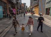 WUHAN. Una faamilia se arriesga a caminar por una de las calles de esta ciudad, tras más de dos meses de cuarentena. Llevan sus rostros protegidos.