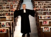 El pastor protestante Klaus-Martin Pothmann está de pie frente a fotos de creyentes de su parroquia que están pegadas a los bancos de la iglesia de San Pankratius en Hamm, Alemania.
