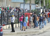 Los ciudadanos siguen aglutinándose en los exteriores de supermercados para abastecerse de víveres. Usan mascarillas, pero no respetan la distancia social.