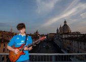 Jacopo Mastrangelo plays the guitar from his terrace overlooking Piazza Navona in Rome  on April 16, 2020, during a lockdown in Italy to curb the spread of the COVID-19 pandemic, caused by the new coronavirus. (Photo by Tiziana FABI / AFP)