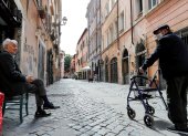 Ancianos protegidos con mascarillas conversan en el barrio de Trastevere, en Roma, Italia, este sábado. Varias regiones del sur de Italia han pedido mantener las restricciones de movimiento para contener la pandemia, después de que el norte, la zona más afectada por el coronavirus, esté presionando al Gobierno para acelerar la reapertura del país. EFE/Riccardo Antimiani