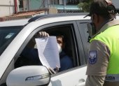 Un conductor muestra su salvoconducto a un oficial de la Policía Nacional.