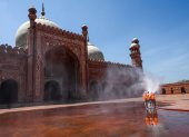 Municipal workers spray disinfectant at the main entrance of the Badshahi mosque ahead of the Muslim holy month of Ramadan during a government-imposed nationwide lockdown as a preventive measure against the COVID-19 coronavirus, in Lahore on April 22, 2020. -  (Photo by ARIF ALI / AFP)