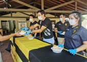 El técnico Gustavo Costas (c) durante la entrega de un guiso de pollo como parte de la iniciativa olla popular.