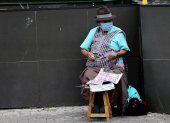 Una mujer con tapabocas vende lotería en las calles de Quito (Ecuador).
