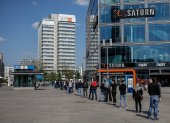 People wait in line to enter an electronics store at Berlin"s Alexanderplatz on April 27, 2020, amid the novel coronavirus COVID-19 pandemic. (Photo by David GANNON / AFP)