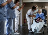 Medical workers clap as Belgian 100 year-old patient Julia Dewilde leaves the Bois de l"Abbaye hospital (CHBA) in Seraing, after being succesfully treated for COVID-19, the disease caused by the novel coronavirus, on April 29, 2020. (Photo by Kenzo TRIBOUILLARD / AFP)
