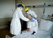 Physiotherapists and members of the medical staff visit a patient at the "middle care" unit for the COVID-19 infected patients at the Erasme Hospital in Brussels, on April 30, 2020 during a lockdown in the country to stop the spread of the novel coronavirus. (Photo by Kenzo TRIBOUILLARD / AFP)