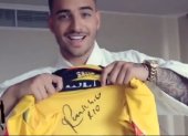 Maluma muestra una camiseta de Barcelona firmada por Ronaldinho.