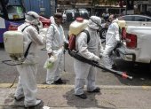 Cleaning workers wearing personal protective equipment (PPE) disinfect a street in Mexico City, on May 7, 2020, amid the new coronavirus pandemic. (Photo by PEDRO PARDO / AFP)
