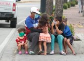 Riesgo. Un padre sale a las calles de Guayaquil con sus cuatro hijos, cuando el semáforo aún indica que se debe mantener el distanciamiento físico.