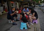 WUHAN. Una familia come en grupo y al aire libre en un restaurante callejero. Esta ciudad china vive ya varios días de una fase de pospandemia.