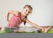 Niña realiza ejercicios e estiramientos.