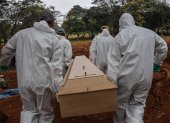 Employees carry the coffin of a person who died from COVID-19 at the Vila Formosa cemetery, in the outskirts of Sao Paulo, Brazil on May 20, 2020. - Brazil has emerged as the latest flashpoint in the coronavirus pandemic. The country has registered more than 270,000 cases and nearly 18,000 deaths so far, and the increase in infections is not expected to peak until June. (Photo by NELSON ALMEIDA / AFP)