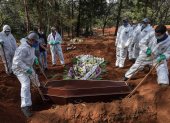 Employees bury the coffin of a person who died from COVID-19 at the Vila Formosa cemetery, in the outskirts of Sao Paulo, Brazil on May 20, 2020. - Brazil has emerged as the latest flashpoint in the coronavirus pandemic. The country has registered more than 270,000 cases and nearly 18,000 deaths so far, and the increase in infections is not expected to peak until June. (Photo by NELSON ALMEIDA / AFP)