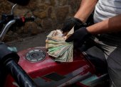 Panorama. Un motociclista necesita una buena cantidad de bolívares y dólares para poder cargar gasolina.