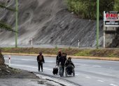 Ciudadanos venezolanos, uno de ellos con discapacidad, transitan el pasado 28 de mayo en una carretera cercana a Quito.