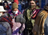 Personas que llevan máscaras faciales caminan por las calles de El Alto mientras Bolivia busca reactivar la economía en medio de la nueva pandemia de coronavirus.