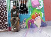 Gabriel Peña, muralista guayaquileño, posando en una de sus pinturas en su sector.