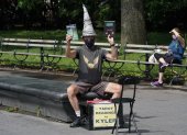 El mago de los juegos y las cartas del tarot, Kyler James, se sienta en el Washington Square Park de Nueva York el 9 de junio de 2020. ¿Cuándo podría haber una vacuna?