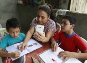 En la cooperativa Sergio Toral, del noroeste de Guayaquil, Melba Alvarado comparte su teléfono entre sus tres hijos para que estos se conecten con sus maestros.