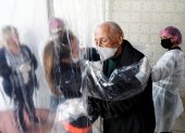 SAO PAULO. María Paula Moraes saluda a su padre Wanderley de 82 años, que vive en una residencia de ancianos, a través de una "cortina de abrazos", una alternativa válida para amenizar las medidas de distanciamiento social, durante el avance de la pandemia del coronavirus en Brasil.