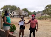La profesora Rocío Ureta entrega las fichas pedagógicas a uno de sus alumnos en la zona rural de Sucre, Manabí.