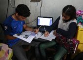 En la cooperativa de vivienda Sergio Toral, del noroeste de Guayaquil, dos hermanos comparten una computadora para sus clases.