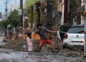 Una niña observa a su padre mientras recupera algunas de sus pertenencias tras las fuertes lluvias este miércoles en Kurume (Japón). Las precipitaciones torrenciales se extendieron hoy al centro de Japón, donde las autoridades han decretado la evacuación de más de 200.000 personas, después de dejar al menos 58 muertos en el sudoeste del país desde el fin de semana. EFE/ Kimimasa Mayama