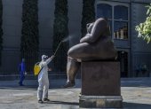 Un trabajador desinfecta una estatua de los artistas colombianos Fernando Botero, en Medellín, en medio de la pandemia de Covid-19