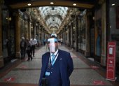 LEED. Un guardia de un área comercial de esta ciudad inglesa, se protege todo el rostro, mientras Inglaterra se prepara para hacer obligatorio el uso de cubiertas faciales en las tiendas.