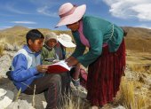 Raymunda Charca (R) helps her children (L-R) Juan Carlos, 13, Alvaro, 10, and Roxana Cabrera, 16, on top of a hill where they can pick up signal on their mobile phones to receive virtual classes during the COVID-19 novel coronavirus pandemic, near their house in the remote highland community of Conaviri, district of Manazo, in the Peruvian Andes close to Lake Titicaca and the border with Bolivia, early July 24, 2020. - As schools remain closed due to the pandemic, the Cabrera children participate in the "Learn at Home" educational platform which was implemented by the Peruvian Ministry of Education. (Photo by Carlos MAMANI / AFP)