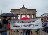 Protestantes en Berlín exponen un cartel que lee: "Alzamos la voz, porque ustedes nos roban la libertad".