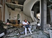 Una mujer se sienta frente a un edificio dañado por la explosión masiva en Beirut, Líbano. Al menos 100 personas murieron y más de 4.000 resultaron heridos.